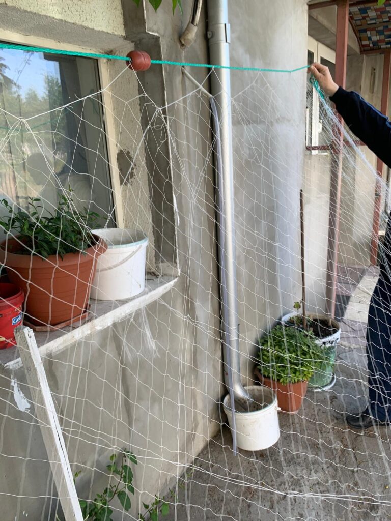 Plasă albă fină întinsă pe o sfoară verde cu flotor